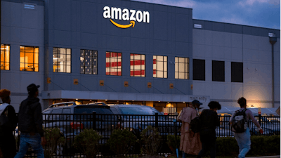 People arrive for work at the Amazon distribution center in the Staten Island borough of New York, Monday, Oct. 25, 2021. The National Labor Relations Board is confirming that a group of Amazon warehouse workers in Staten Island, New York has withdrawn its petition to hold a vote to unionize its workers.