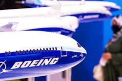 A woman walks by models of Boeing Co. aircraft, including the manufacturer's new Boeing 777X, at the Dubai Air Show in Dubai, United Arab Emirates, Wednesday, Nov. 17, 2021.