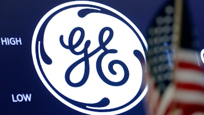 The General Electric logo appears above a trading post on the floor of the New York Stock Exchange, June 26, 2018. General Electric is splitting itself into three public companies that concentrate on aviation, healthcare and energy. The company said Tuesday, Nov. 9, 2021, that it plans a spinoff of its healthcare business in early 2023 and of its energy segment in early 2024.