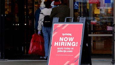 Hiring sign is displayed outside of a retail store in Vernon Hills, Ill., Saturday, Nov. 13, 2021. The number of Americans applying for unemployment benefits plummeted last week to the lowest level in more than half a century, another sign that the U.S. job market is rebounding rapidly from last year’s coronavirus recession.