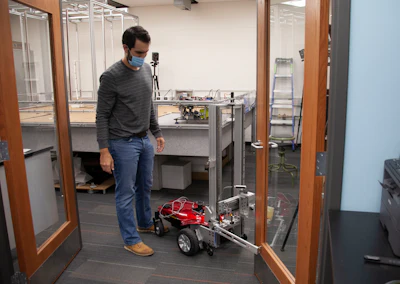 UC engineering student Sam King demonstrates how the autonomous robot will work once complete. Translating the successful AI simulation to a real-world robot could take months of development.