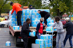Volunteers prepare bottled water to be distributed to residents at the local high school parking lot Thursday, Oct. 21, 2021, in Benton Harbor, Mich. The water system in Benton Harbor has tested for elevated levels of lead for three consecutive years. In response, residents have been told to drink and cook with bottled water and the state has promised to spend millions replacing lead service lines.