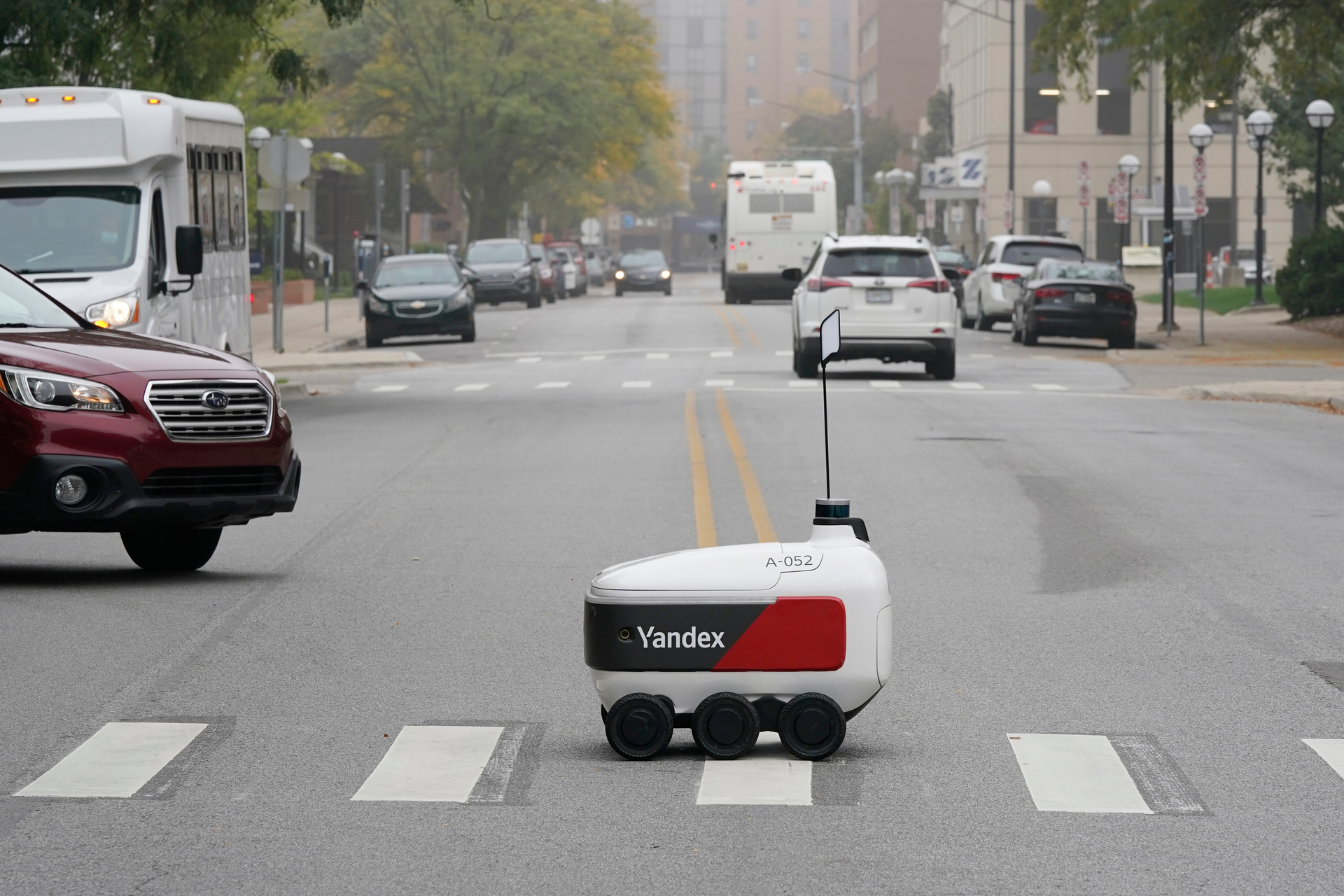 A food delivery robot crosses a street in Ann Arbor, Mich. on Thursday, Oct. 7, 2021. Robot food delivery is no longer the stuff of science fiction. Hundreds of little robots __ knee-high and able to hold around four large pizzas __ are now navigating college campuses and even some city sidewalks in the U.S., the U.K. and elsewhere.