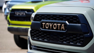 The company logo highlights the grille of a 2021 Tacoma pickup truck on display in the Toyota exhibit at the Denver auto show Friday, Sept. 17, 2021, at Elitch's Gardens in downtown Denver. Japan’s top automaker Toyota reported Thursday, Nov. 4, 2021, a 33% jump in second fiscal quarter profit, as it raised its full year forecast, despite supply chain woes related to the coronavirus pandemic.