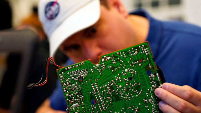A volunteer repairs a circuit board at a fortnightly repair café event in Malmo, southern Sweden, Sunday Nov. 14, 2021.