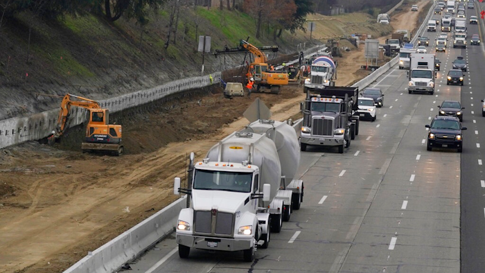 Trucks and other vehicles pass a construction zone on Highway 50 in Sacramento, Calif., Monday, Dec. 6, 2021. The California Air Resources Board, on Thursday, Dec. 9, 2021, is considering a new smog check program for heavy duty trucks. The new rules would require trucks weighing more than 14,000 pounds to be tested at least twice per year to make sure they meet the state's smog standards.