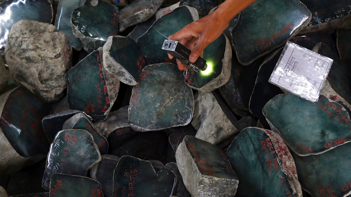 A merchant examines a jade stone displayed at the Gems Emporium in Naypyitaw, Myanmar on Nov. 13, 2018. Human rights activists are lobbying major jewelers to stop buying gems sourced in Myanmar as a way to exert pressure on Myanmar’s military leaders by limiting profits from the country’s lucrative mining industry.