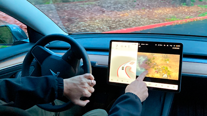 Vince Patton, a new Tesla owner, demonstrates on Dec. 8, 2021, on a closed course in Portland, Ore., how he can play video games on the vehicle's console while driving. The U.S. has opened a formal investigation into a report that Tesla vehicles allow people to play video games on a center touch screen while they are driving.