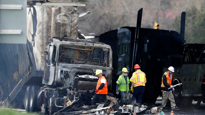 Workers clear debris from the eastbound lanes of Interstate 70 on April 26, 2019, in Lakewood, Colo., following a deadly pileup involving a semi-truck hauling lumber. A truck driver who was convicted of causing the fiery pileup that killed four people and injured six others on Interstate 70 west of Denver was sentenced Monday, Dec. 13, 2021, to 110 years in prison. Rogel Aguilera-Mederos was convicted in October of vehicular homicide and other charges stemming from the April 2019 crash.