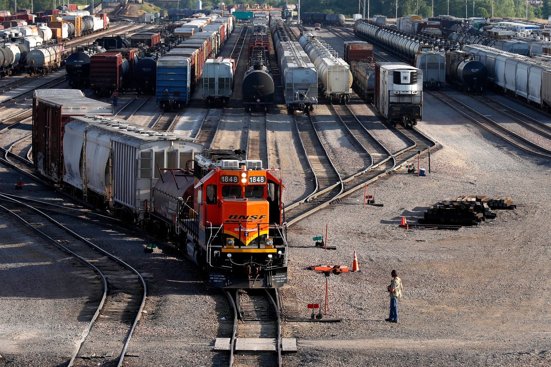 A BNSF rail terminal worker monitors the departure of a freight train in Galesburg, Ill., June 15, 2021.