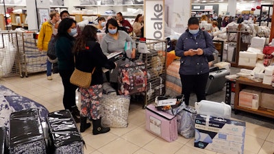 Customers wait in line to checkout during a Black Friday sale at Macy's on Nov. 26, 2021, in Indianapolis.