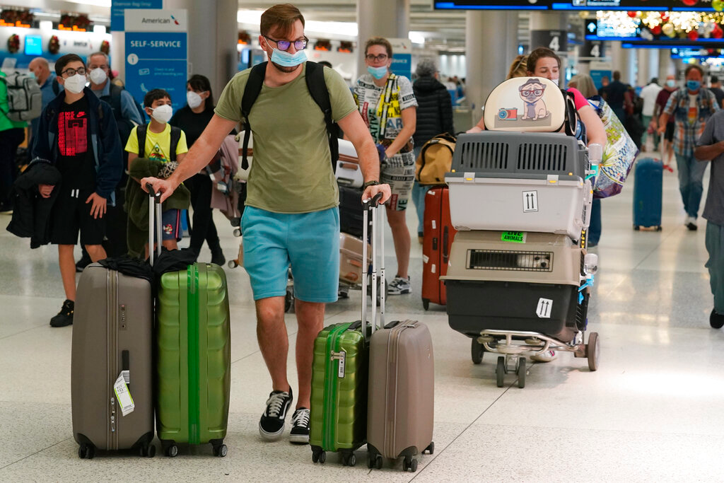 A family and their pets walk through Miami International Airport, on Dec. 20, 2021, in Miami.