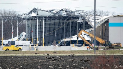 Crews move in heavy equipment for search and rescue operations at the Amazon distribution center in Edwardsville, Ill., on Saturday, Dec. 11, 2021. Overnight severe storms caused the building to partially collapse with confirmed fatalities according to police. The roof of the building was ripped off and a wall about the length of a football field collapsed.