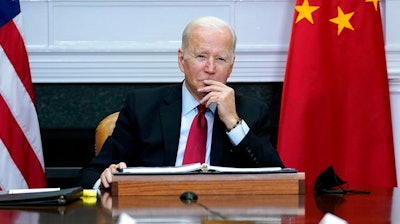 President Joe Biden listens as he meets virtually with Chinese President Xi Jinping from the Roosevelt Room of the White House in Washington,Nov. 15, 2021. The Biden administration announced on Thursday that it is levying new sanctions against several Chinese biotech and surveillance companies operating out of Xinjiang province, casting another shot at Beijing over human rights abuses against Uyghurs in western China.