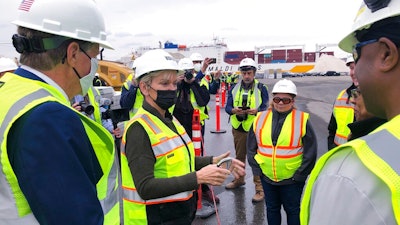 U.S. Energy Secretary Jennifer Granholm, center, speaks with workers, and Rhode Island Gov. Dan McKee, left, Thursday Dec. 2, 2021, while visiting an under construction fabrication and assembly facility for offshore wind turbines at the Port of Providence, in Providence, R.I. The building is scheduled to be finished this spring to support two offshore wind projects, Revolution Wind and South Fork Wind.