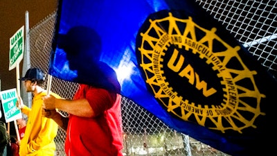 A General Motors employee who works on the line, waves a United Auto Workers flag as employees leave the Flint Assembly Plant at midnight as part of the national strike on, Sept. 16, 2019, in Flint, Mich. Members of the United Auto Workers union appear to be in favor of picking their leaders in direct elections. A federal court-appointed monitor who is conducting the election said on his website Wednesday, Dec. 1, 2021, that 65,136 ballots were cast in favor of direct elections, while 38,503 wanted delegate voting. The results are unofficial and the full count likely won't be done until Thursday, the website said.