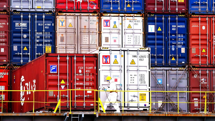 A worker in protective overall works near containers on a ship in Qingdao in east China's Shandong province on Nov. 7, 2021. China’s economy grew by 8.1% in 2021 after an abrupt slowdown in the second half that is prompting suggestions Beijing needs to shore up slumping growth, government data showed Monday, Jan. 17, 2022.