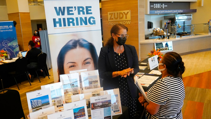 Marriott human resources recruiter Mariela Cuevas, left, talks to Lisbet Oliveros, during a job fair at Hard Rock Stadium, Friday, Sept. 3, 2021, in Miami Gardens, Fla. Federal Reserve policymakers at a meeting last month said the U.S. job market was nearly at levels healthy enough that the central bank's low-interest rate policies were no longer needed. That's according to minutes of the meeting released Wednesday, Jan. 5, 2022.