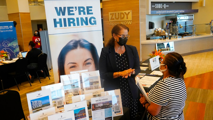 Marriott human resources recruiter Mariela Cuevas, left, talks to Lisbet Oliveros, during a job fair at Hard Rock Stadium, Friday, Sept. 3, 2021, in Miami Gardens, Fla. Federal Reserve policymakers at a meeting last month said the U.S. job market was nearly at levels healthy enough that the central bank's low-interest rate policies were no longer needed. That's according to minutes of the meeting released Wednesday, Jan. 5, 2022.