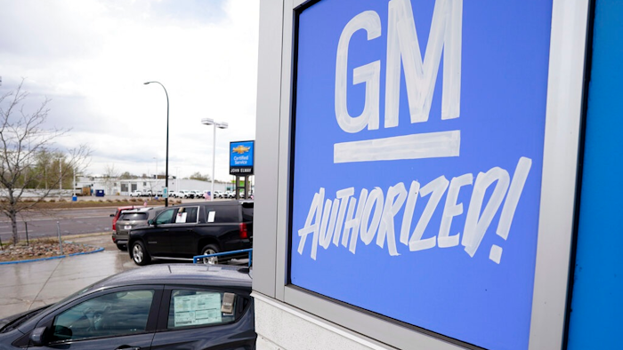 In this May 2, 2021, file photo, a General Motors sign hangs on the side of a Chevrolet showroom in Englewood, Colo. Michigan's economic development board on Tuesday, Jan. 25, 2022 approved $824 million in incentives and assistance for General Motors Co. to put electric vehicle and battery plants in its home state, adding as many as 4,000 jobs.
