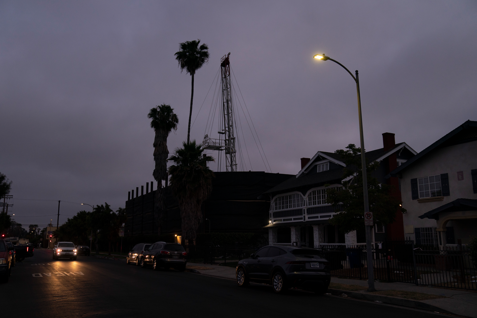 A vehicle drives past the Jefferson oil drill site in Los Angeles, June 2, 2021.