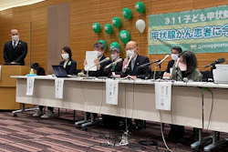 Flanked by other lawyers, a plaintiff and the mother of another, lawyer Yuichi Kaido, third from left, shows a court document during a news conference, Tokyo, Jan. 27, 2022.