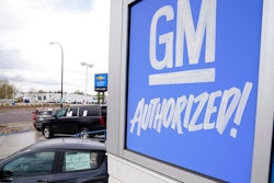 In this May 2, 2021, file photo, a General Motors sign hangs on the side of a Chevrolet showroom in Englewood, Colo. Michigan's economic development board on Tuesday, Jan. 25, 2022 approved $824 million in incentives and assistance for General Motors Co. to put electric vehicle and battery plants in its home state, adding as many as 4,000 jobs.