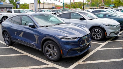 A pair of 2021 Ford Mustang Mach E are displayed for sale at a Ford dealer on Thursday, May 6, 2021, in Wexford, Pa. U.S. new vehicle sales rebounded slightly last year from 2020′s dismal numbers, but forecasters expect them to be more than 2 million below the years before the coronavirus pandemic.
