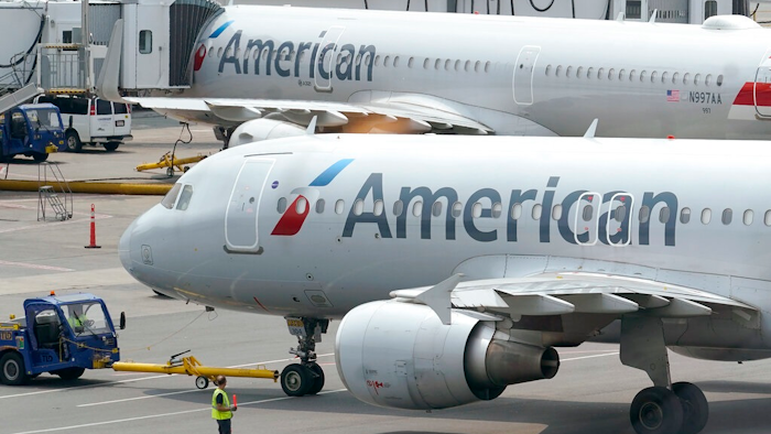 American Airlines passenger jets prepare for departure, on July 21, 2021, at Boston Logan International Airport in Boston. American Airlines is making further cuts in its international schedule for this summer because of delays in Boeing delivering new widebody planes, the company announced Friday, Feb. 18, 2022.