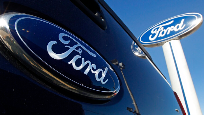 This Oct. 25, 2011 file photo shows a Ford logo on the tailgate of a pick-up truck, and on a Ford dealership sign in Salem, N.H. Ford Motor Co. reversed a loss and rode some big accounting changes to post a $17.94 billion net profit last year, even as it battled computer chip shortages that caused factory slowdowns and vehicle shortages.