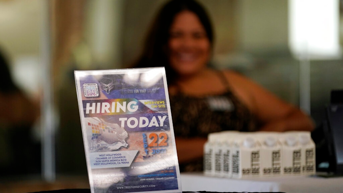 A hiring sign is placed at a booth for prospective employers during a job fair Wednesday, Sept. 22, 2021, in the West Hollywood section of Los Angeles. The number of Americans applying for unemployment benefits rose to the highest level in three months as the fast-spreading omicron variant disrupted the job market. Jobless claims rose for the third straight week — by 55,000 to 286,000, highest since mid-October, the Labor Department reported Thursday, Jan. 20, 2022.