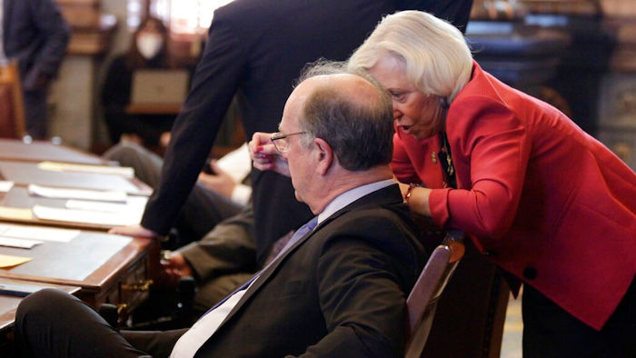 Kansas state Sens. Jeff Longbine, left, R-Emporia, and Pat Pettey, D-Kansas City, confer as the Senate votes on a measure to allow the state to offer more than $1 billion in breaks to an unnamed company to bring a $4 billion project to Kansas, Wednesday, Feb. 9, 2022, at the Statehouse in Topeka, Kan. Both Longbine and Pettey supported the measure, which is designed to seal a deal with the company to create 4,000 jobs.