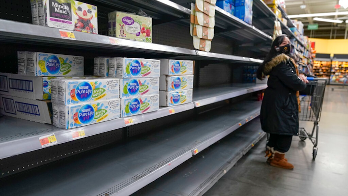 A woman looks over shelves, some of which are empty, at a Walmart store in Teterboro, N.J., on Jan. 12, 2022. The Justice Department is launching a new initiative aimed at identifying companies that exploit supply chain disruptions in the U.S. to make increased profits in violation of federal antitrust laws.