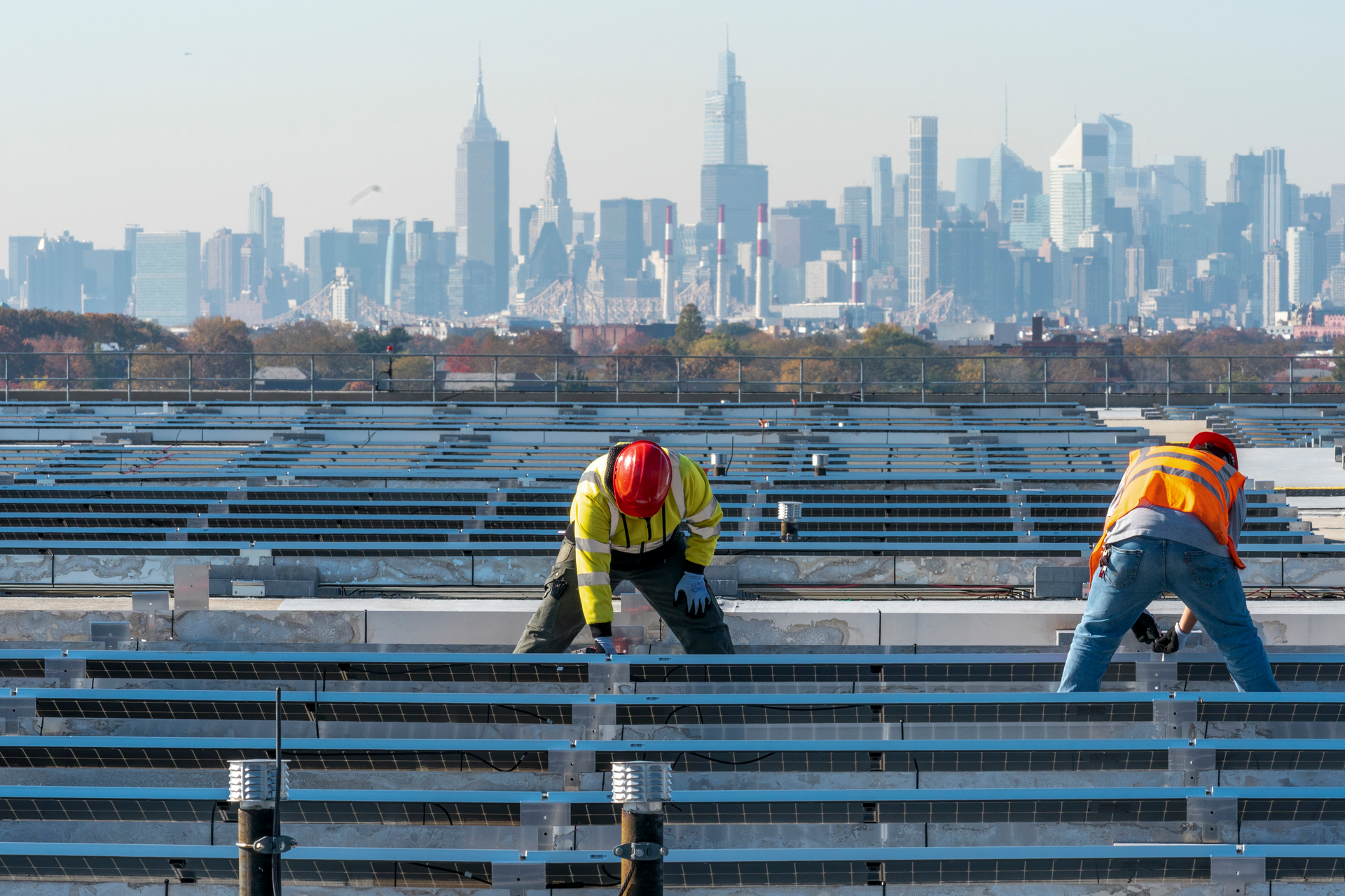 Electricians with IBEW Local 3 install solar panels on top of the Terminal B garage at LaGuardia Airport, New York, Nov. 9, 2021.