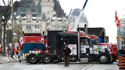 Trucks are parked in front of the Chateau Laurier as a protest against COVID-19 restrictions continue in Ottawa on Feb. 10, 2022.
