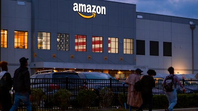 People arrive for work at the Amazon distribution center in the Staten Island borough of New York on Oct. 25, 2021.