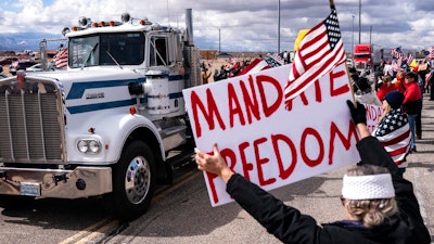 Supporters cheer on the beginning of a trucker caravan to Washington, D.C., called The People's Convoy on Feb. 23, 2022, in Adelanto, Calif. A small convoy of truckers demanding an end to coronavirus mandates began a cross-country drive from California to the Washington, D.C., area on Wednesday.