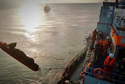 Firefighters remove a body from the Italian-flagged Euroferry Olympia, which is on fire for third day, in the Ionian Sea near the Greek island of Corfu, on Sunday, Feb. 20, 2022. A survivor has been rescued Sunday morning from the stern of a still burning passenger ferry, Greece's coast guard said.