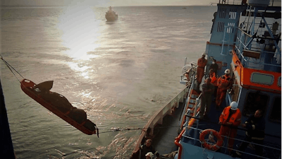 Firefighters remove a body from the Italian-flagged Euroferry Olympia, which is on fire for third day, in the Ionian Sea near the Greek island of Corfu, on Sunday, Feb. 20, 2022. A survivor has been rescued Sunday morning from the stern of a still burning passenger ferry, Greece's coast guard said.