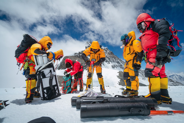 Mariusz Potocki and Sherpa team drilling the highest ice core ever recovered at 8020m elevation with the summit of Mount Everest in the background.