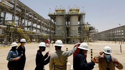 Saudi Aramco engineers and journalists look at the Hawiyah Natural Gas Liquids Recovery Plant, which is designed to process 4.0 billion standard cubic feet per day of sweet gas, a natural gas that does not contain significant amounts of hydrogen sulfide, in Hawiyah, in the Eastern Province of Saudi Arabia, June 28, 2021. Leaders of the world's most consequential energy bodies gathered for a forum Wednesday, Feb. 16, 2022, to discuss the uncertain future of oil as demand rebounds and prices climb, all while a growing roster of nations pledge to transition to cleaner forms of energy.