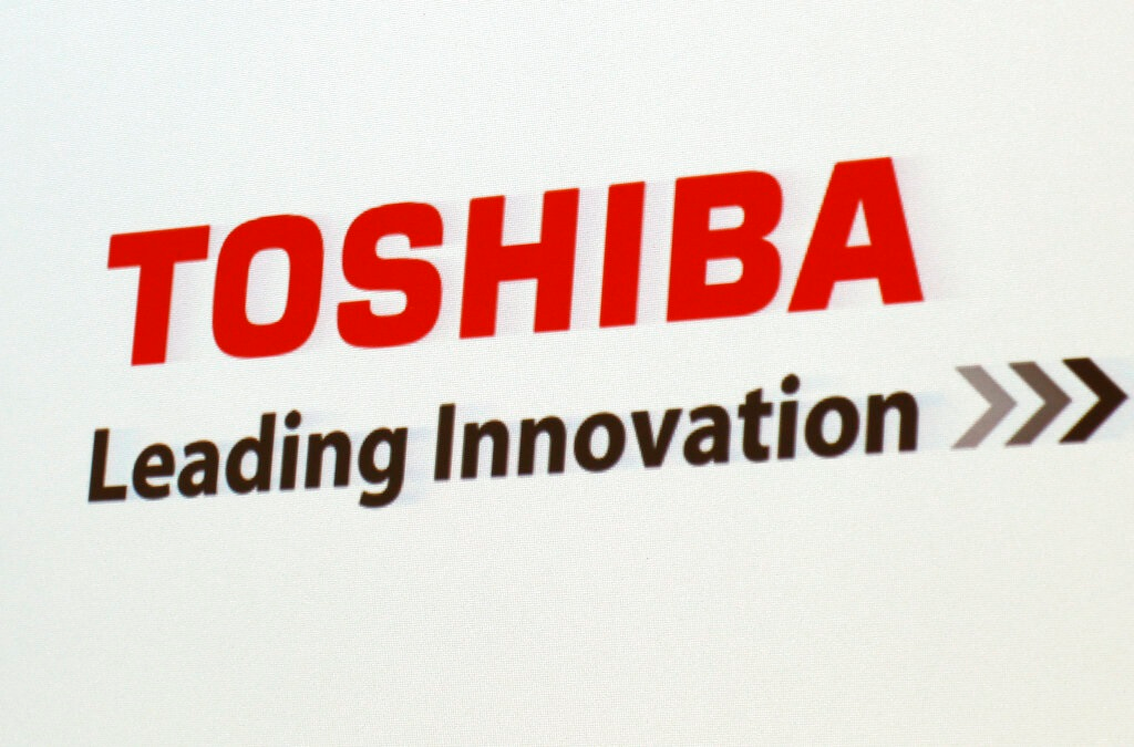 In this June 15, 2017, file photo, the logo of Toshiba Corp., Japan's electronics and energy company, is seen on a screen during a press conference in Yokosuka, near Tokyo. Embattled Japanese technology giant Toshiba on Monday, Feb. 7, 2022, announced it is splitting into two companies, one focused on infrastructure and the other on devices, to try to bring value to shareholders.
