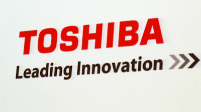 In this June 15, 2017, file photo, the logo of Toshiba Corp., Japan's electronics and energy company, is seen on a screen during a press conference in Yokosuka, near Tokyo. Embattled Japanese technology giant Toshiba on Monday, Feb. 7, 2022, announced it is splitting into two companies, one focused on infrastructure and the other on devices, to try to bring value to shareholders.