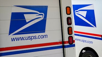 In this Aug. 18, 2020, file photo, mail delivery vehicles are parked outside a post office in Boys Town, Neb. The U.S. Postal Service says it has cleared the final regulatory hurdle to placing orders for next-generation mail vehicles. That keeps the Postal Service on track for taking delivery of the first of the electric- and gas-powered delivery vehicles next year. Postmaster General Louis DeJoy said Wednesday, Feb. 23, 2022 that the completion of an evaluation required by the National Environmental Policy Act is an important milestone for postal carriers who’ve soldiered on with overworked delivery trucks that went into service from 1987 to 1994.