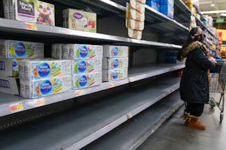 A woman looks over shelves, some of which are empty, at a Walmart store in Teterboro, N.J., on Jan. 12, 2022. The Justice Department is launching a new initiative aimed at identifying companies that exploit supply chain disruptions in the U.S. to make increased profits in violation of federal antitrust laws.