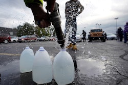 Kevin Stack of the Berrien County Road Department fills jugs with non-potable water in the Benton Harbor High School parking lot, Benton Harbor, Mich., Oct. 21, 2021.