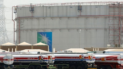 Fuel trucks line up in front of storage tanks at the North Jiddah bulk plant, an Aramco oil facility, in Jiddah, Saudi Arabia, on March 21, 2021.