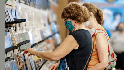 Judy Gallagher, left, wears a mask as she looks through music at the Ernest Tubb Record Shop on June 29, 2020, in Nashville, Tenn.