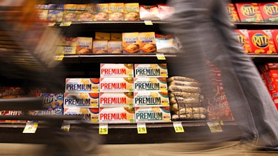 In this Feb. 9, 2011 photo, a shopper passes Nabisco products, a Mondelez International brand: Premium saltines, Triscuits, Ritz crackers and Wheat Thins, at a supermarket in Los Angeles. Ukrainian President Volodymyr Zelenskyy is stepping up the country's pleas to pressure companies to exit Russia.