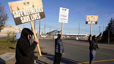Operators holds up picket signs and acknowledge honking horns outside the Chevron Corp. refinery on March 21, 2022, in Richmond, Calif.